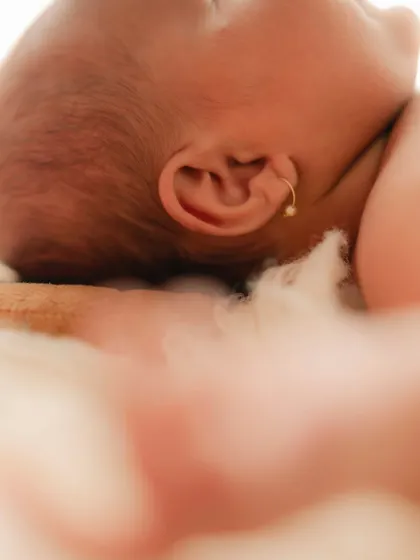 A macro shot of a newborn's tiny ear and the soft hair on their head. These detail shots are a beautiful addition to any newborn gallery.