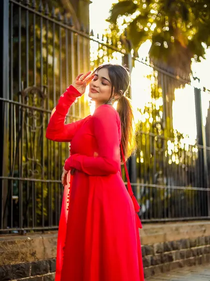 A beautiful outdoor portrait in a red dress, captured with the warm glow of the setting sun.