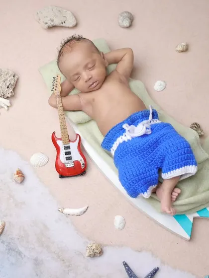 A creative twist on our beach theme, with the baby relaxing on a surfboard holding a tiny guitar. This overhead shot is playful and unique.
