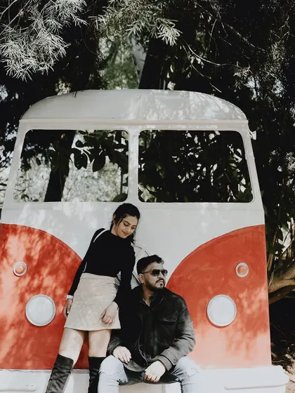 A cool and stylish pose with a vintage Volkswagen bus prop, perfect for a couple looking for a retro, indie-vibe photoshoot.