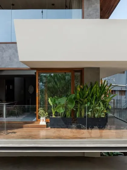A cantilevered balcony at the Timber Edge project, featuring a wooden deck and planters that create a green oasis in an urban setting.