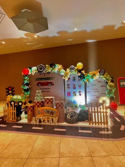 An identical wide shot of the impressive car-themed setup for Avyaan's birthday.