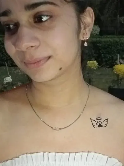 A sweet little angel wing paw print on the collarbone, a beautiful tribute for a beloved pet.