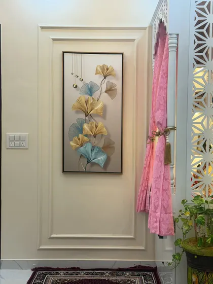 This view shows the pooja unit in the context of the room, next to a wall with decorative molding and artwork, creating a harmonious and elegant corner.