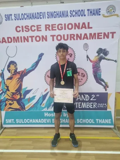 A proud moment for Zehn, posing with his silver medal in front of the tournament banner. His hard work is an inspiration to his peers.
