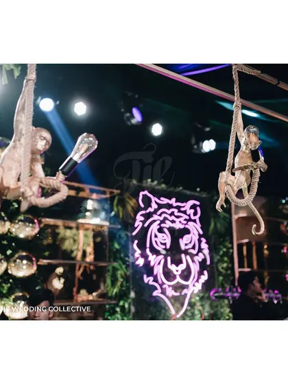 This detail shot highlights the playful and unique elements we love to incorporate, like these custom monkey figures holding light fixtures above the bar. It's these imaginative touches that make an event truly unforgettable.