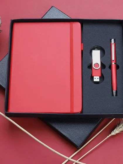 We deliver clean, sharp product photography for corporate merchandise. This image of a premium red gift set, containing a notebook, pen, and USB drive, is an example of our catalog-ready shots, presented in its packaging for a professional look.