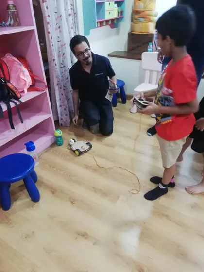 An instructor gives one-on-one guidance to a student with his remote-controlled car. We ensure every child gets the attention they need to succeed.