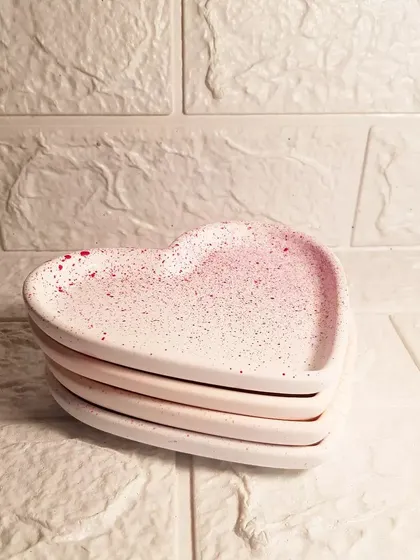 A stack of our heart trinket trays, showing the subtle variations in the handmade splatter design. Each one is unique.