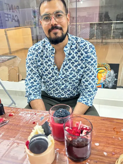 A guest with his unique set of dessert candles, including a black rose and a macaron-topped creation.
