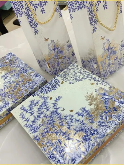 A close-up of the custom-printed boxes and bags, showing the fine details of the gold foil and delicate butterfly motifs.