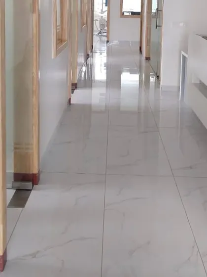 The main corridor of the clinic, featuring glossy tiled floors and wood-trimmed doorways leading to treatment rooms.