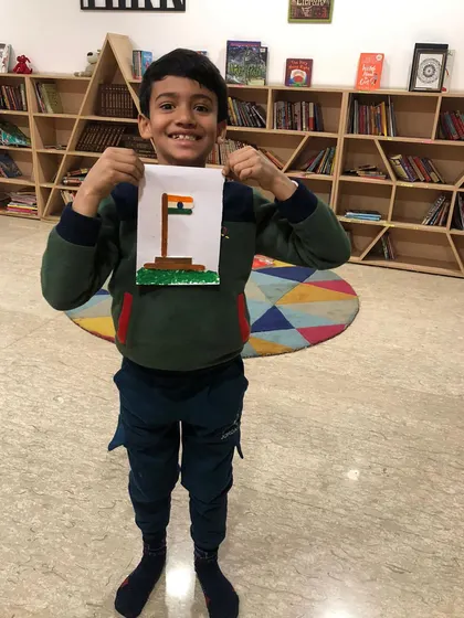 A proud student with his Republic Day craft, a beautiful mosaic of the Indian flag.
