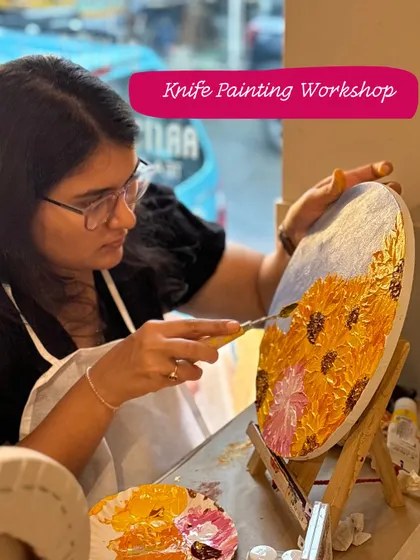 A participant using a palette knife to create a textured sunflower painting. Knife painting allows for bold, expressive strokes and a wonderful 3D effect.