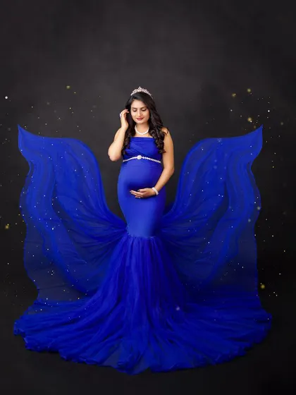 A royal blue gown with sparkling fabric wings creates a magical, celestial effect. This is for the mother-to-be who wants to feel like a star.