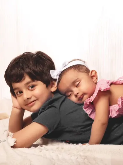 There's nothing like a sibling hug. A tender moment as a baby girl naps on her big brother's back.