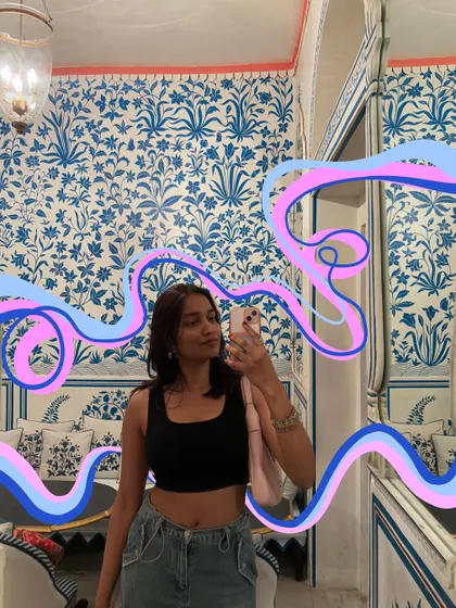 A mirror selfie in a beautifully decorated room in Jaipur, with doodles that match the blue and pink tones.