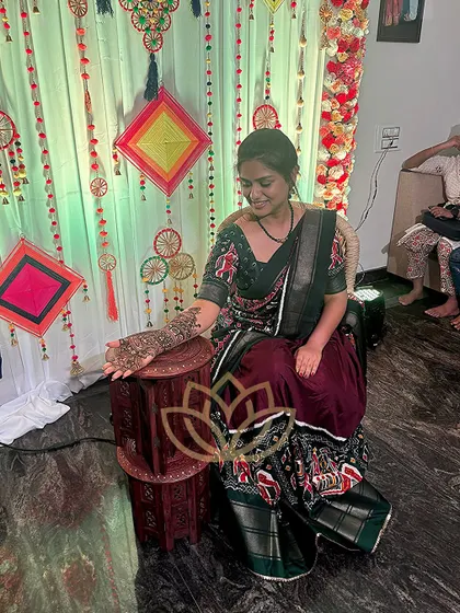 A guest at a mehendi function, her hands beautifully adorned with an intricate design.