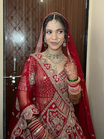 This bride looks absolutely radiant in her red lehenga. The makeup is classic and clean, with a focus on enhancing her features and ensuring the look is timeless.