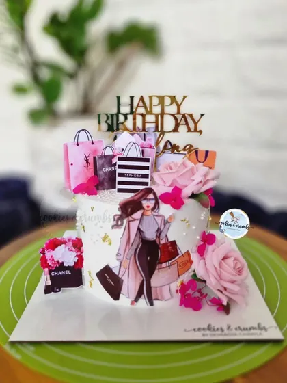 The perfect cake for a shopaholic. This design is decorated with edible toppers of designer shopping bags like Chanel and Sephora, along with fresh pink roses.