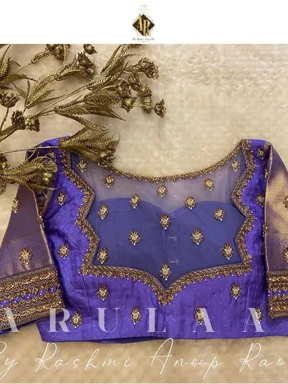 This lavender blouse features a sheer net yoke with scattered butis. It's a modern take on a traditional design, perfect for a contemporary look.