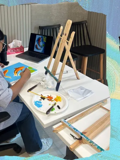 Here's a participant at a corporate workshop, referencing a design on her laptop to create her own koi fish painting. I can tailor the art theme to fit your company's goals or event.