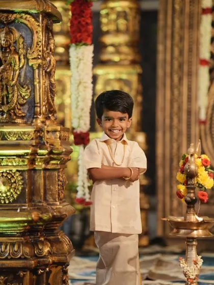 A charming portrait of a young boy dressed in traditional South Indian attire. Capturing the little ones in their festive best adds a sweet and adorable element to the wedding album.