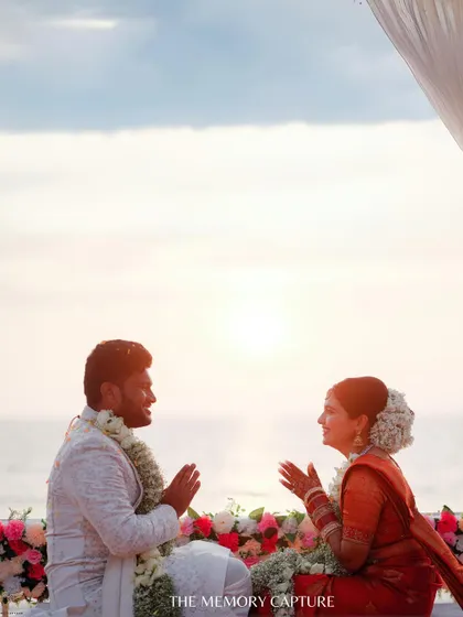 A perfect sundowner moment. The couple is captured in silhouette against the setting sun over the ocean, creating a beautifully romantic and serene image.