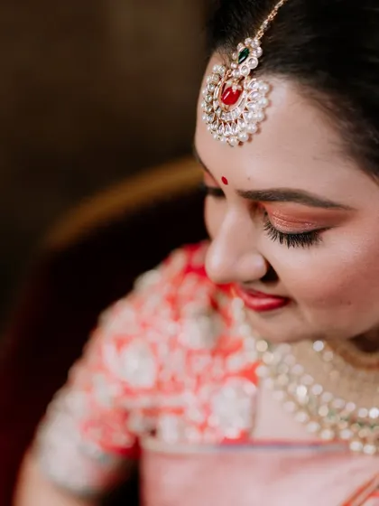 A detailed close-up of the bride's maang tikka and eye makeup.