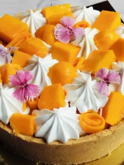 My New York-style eggless baked cheesecake, topped with the sweetness of seasonal mangoes and edible flowers. It's rich, creamy, and utterly decadent.
