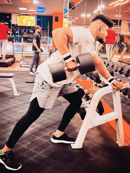 Building a strong back is fundamental to overall fitness. A client performs a single-arm dumbbell row with perfect form, a key exercise in our personal training programs for developing back strength and posture.