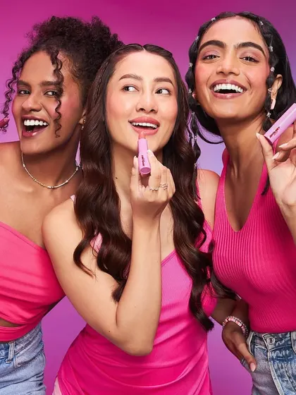 For the Joyology Beauty launch, this image focuses on the application of pink lipsticks. The makeup is fresh and joyful, with a focus on healthy, glowing skin to complement the playful lip colors.