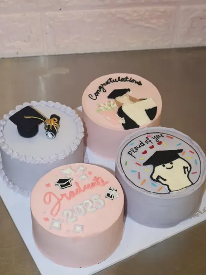 Celebrating a huge achievement with a sweet treat! This set of four graduation-themed bento cakes includes hand-piped illustrations, a fondant graduation cap, and congratulatory messages for the class of 2025.