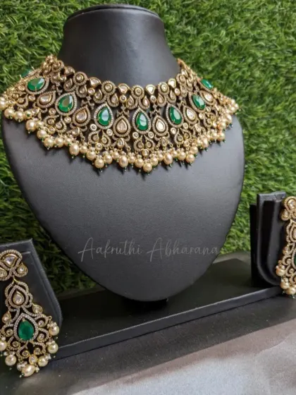 This is a beautiful choker and earring set with an antique finish, but the polki-style stones and emerald green drops give it a modern feel. It's perfect for a sangeet or reception.