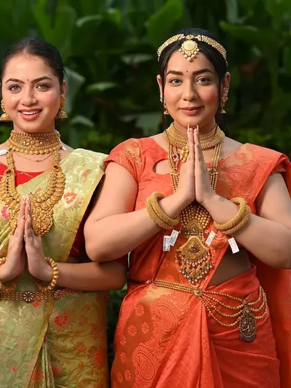 Two models in traditional attire for a jewellery brand, posing with a welcoming 'namaste'. This creates a culturally rich and inviting image for the brand.