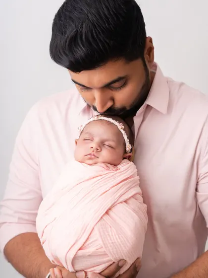 A father's love. This portrait of a dad kissing his newborn's head is a classic and heartwarming image.