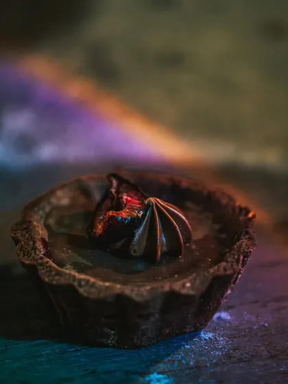 A dramatic shot of a rich chocolate tart, highlighted with a touch of rainbow light. This image showcases my creative use of lighting to add a unique and artistic flair to dessert photography.