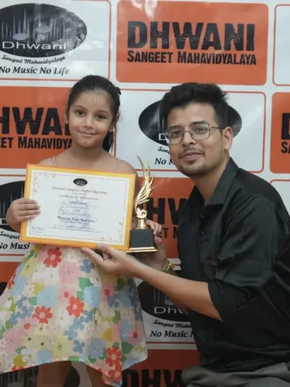 A teacher presents an award to his young student.