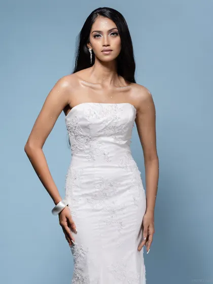 A classic full-body shot of the model in the white bridal gown.