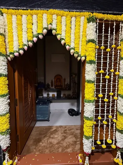 A traditional floral decoration for the entrance of a home for a Haldi ceremony, using yellow and white flowers.