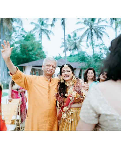 The bride shares a happy moment with her father during the Haldi ceremony, a beautiful candid capture.