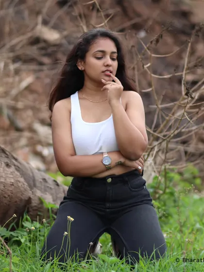 A thoughtful pose in a natural environment. The soft lighting and earthy tones create a calm and introspective mood.
