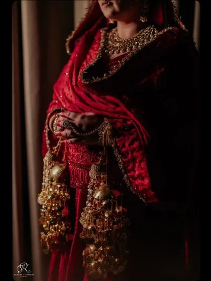 A close-up detail shot focusing on the bride's hands and the traditional kaleerey.
