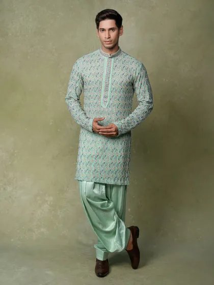 A full-length portrait for a men's ethnic wear brand, showcasing a complete coordinated look from head to toe.