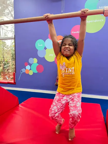 The face of determination. This 'mini queen' is giving it her all as she practices on the bars, building strength and confidence with every swing.