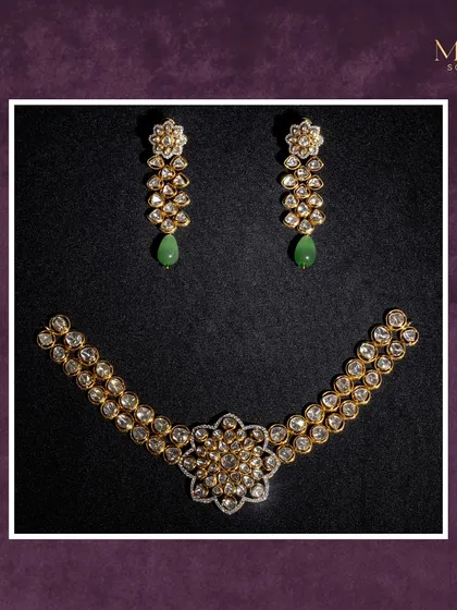 This beautiful Polki set features a floral-inspired necklace and matching earrings with a hint of green. The double-layered chain of uncut diamonds adds a touch of sophistication and grace.
