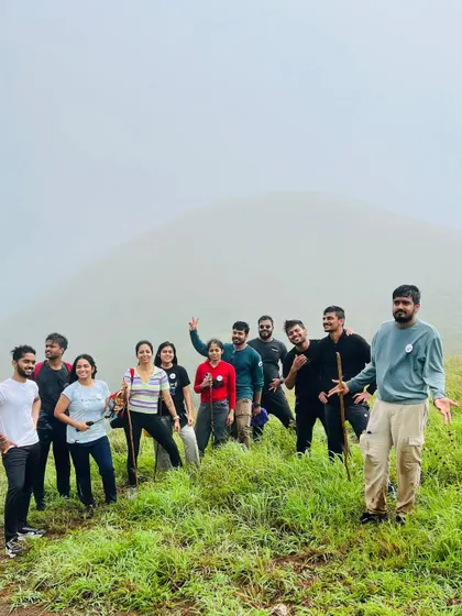 A candid group photo on the trail, with the misty hills behind.