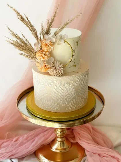 A closer look at the details of this modern bohemian two-tier cake, highlighting the delicate textures and natural elements.