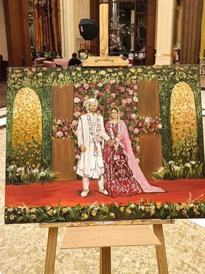 The finished painting from a Delhi wedding, displayed on its easel. This view shows the artwork in its full context, ready for the couple.