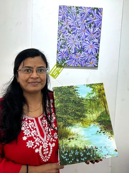 Holding my landscape painting at the gallery.